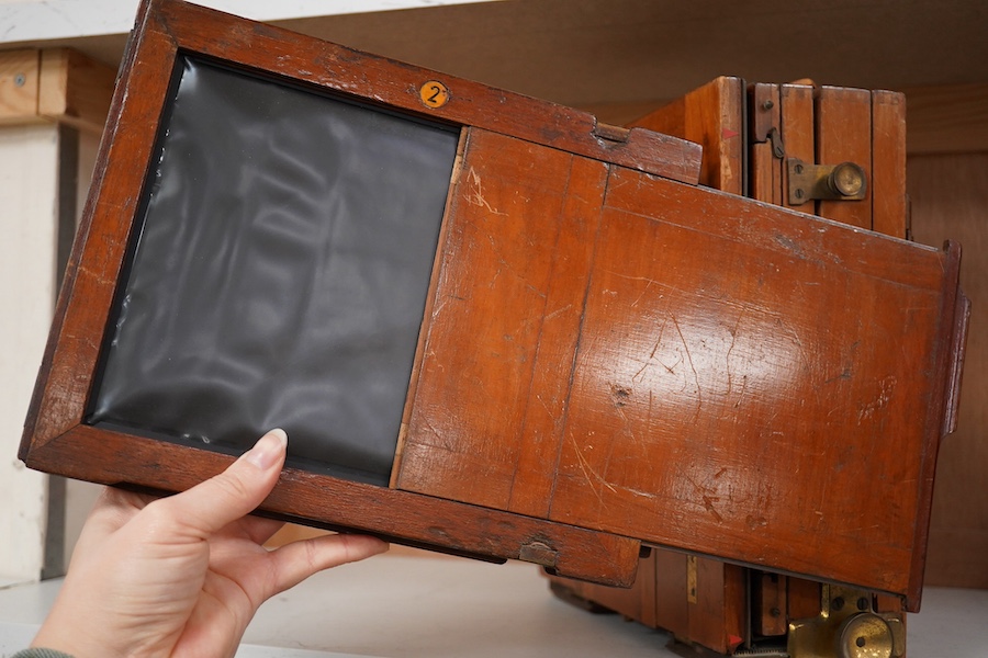 An early 20th century brass mounted mahogany full plate camera, together with a glass negative holder. Condition - fair to good.